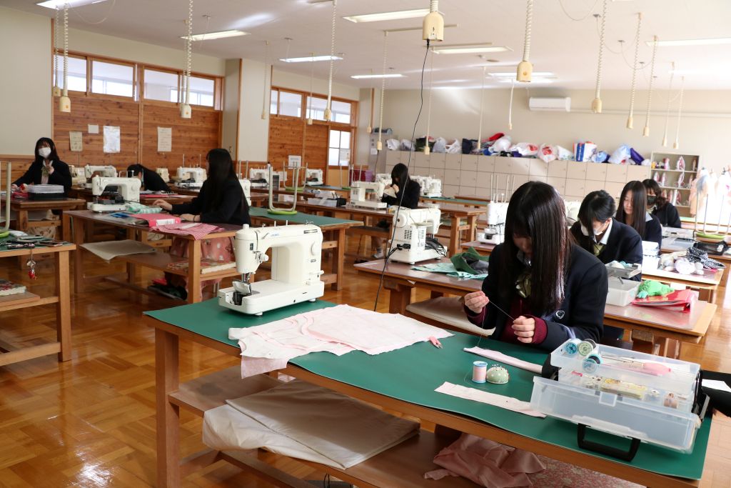 "諏訪実業高校 服飾科 作業台で裁断や制作に取り組む授業風景"