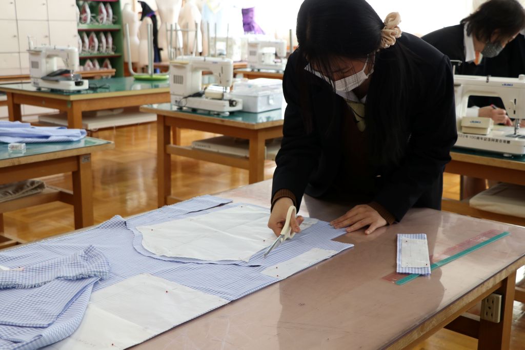 "諏訪実業高校 服飾科 型紙を使って裁断作業を行う生徒の様子"